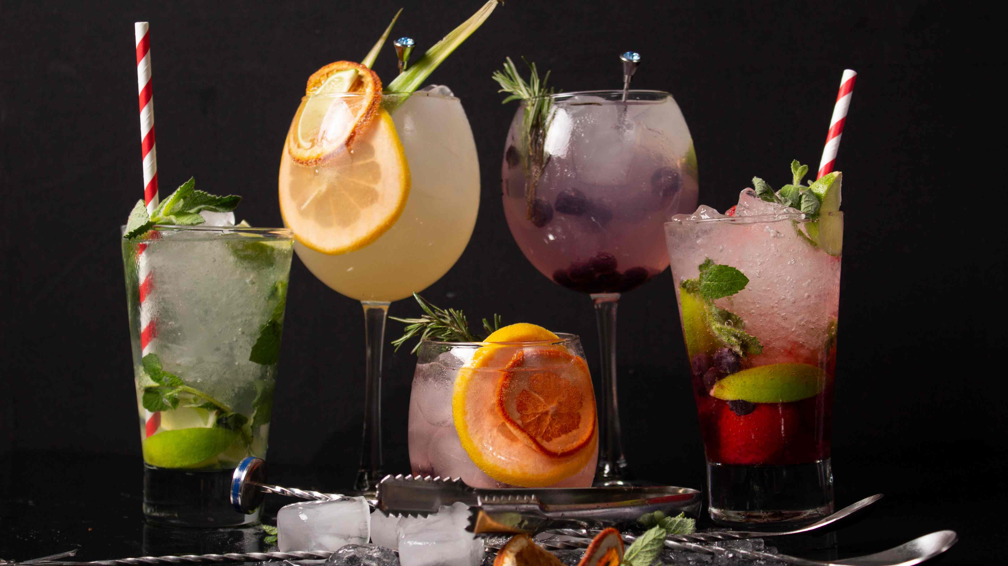 Colorful non-alcoholic cocktails with garnishes and bar tools